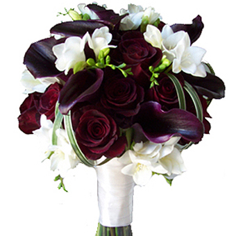 Striking wedding bouquet featuring deep burgundy roses, dark calla lilies, and white freesia, perfect for adding elegance and contrast to bridal arrangements.