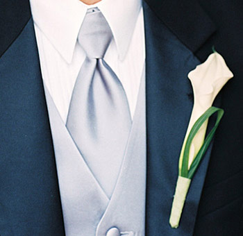 Wedding boutonniere featuring mini calla lilies in warm mango tones, designed for grooms, groomsmen, and formal wedding attire.