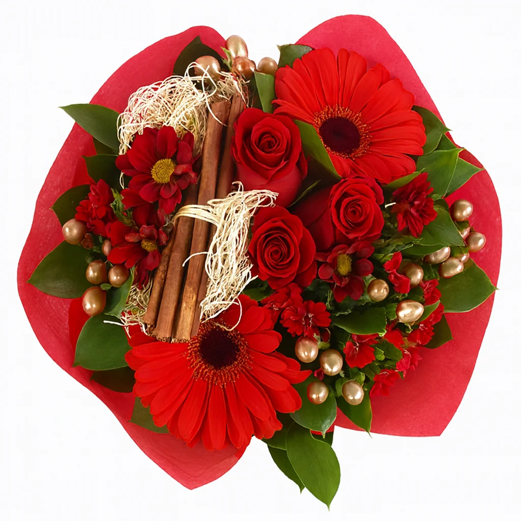 Festive Christmas Joy flower centerpiece featuring red roses, gerbera daisies, greenery, and cinnamon sticks, perfect for adding holiday warmth and cheer to your seasonal décor.
