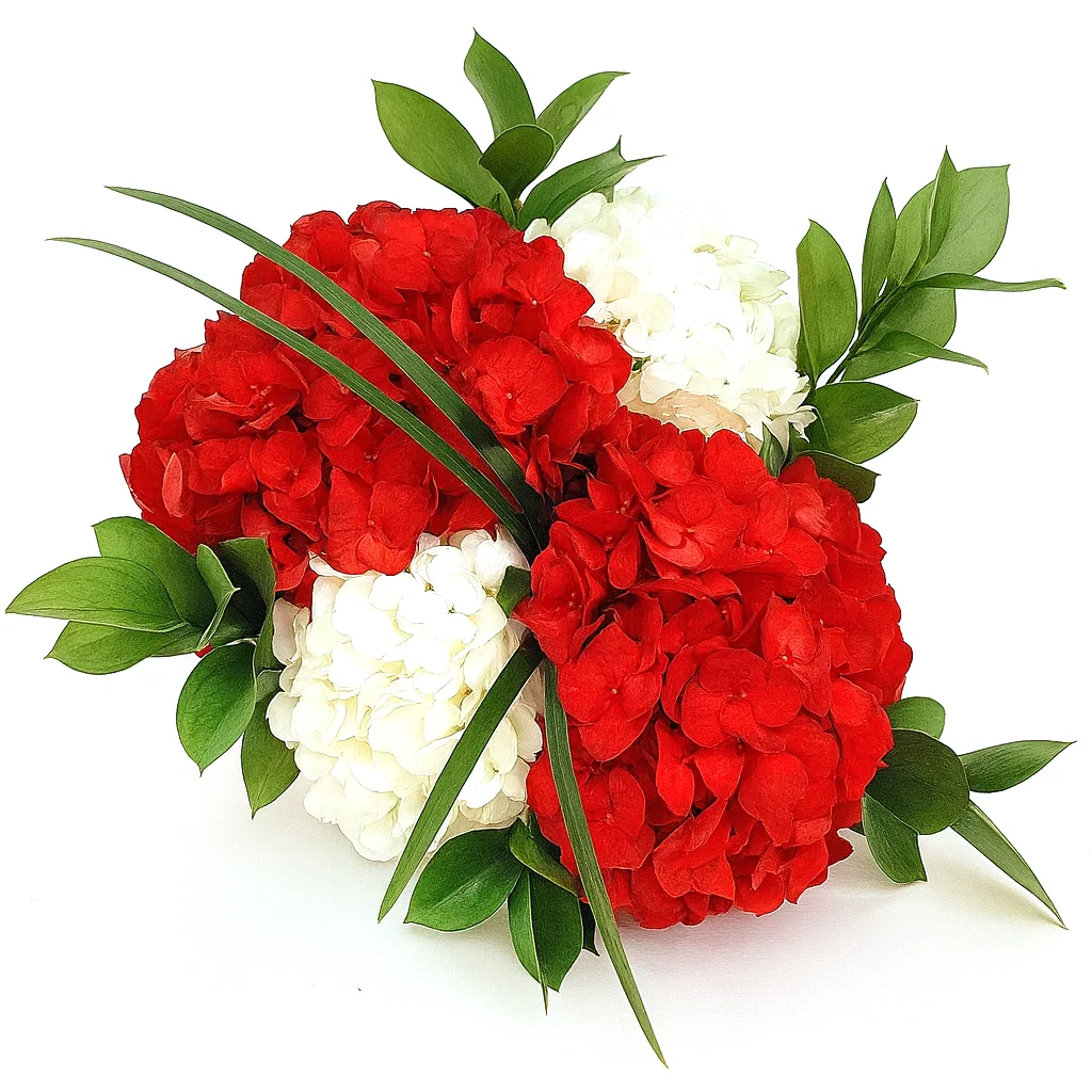 Close-up of painted hydrangea centerpiece in bold red, crimson, and white with fresh greenery accents for formal floral décor or patriotic events.