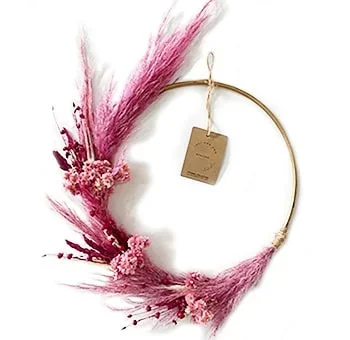A round-shaped decorative wreath made with dried flowers and foliage for Valentine’s Day.