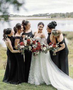 Bridal party by a lake with their bouquets with fall colors.