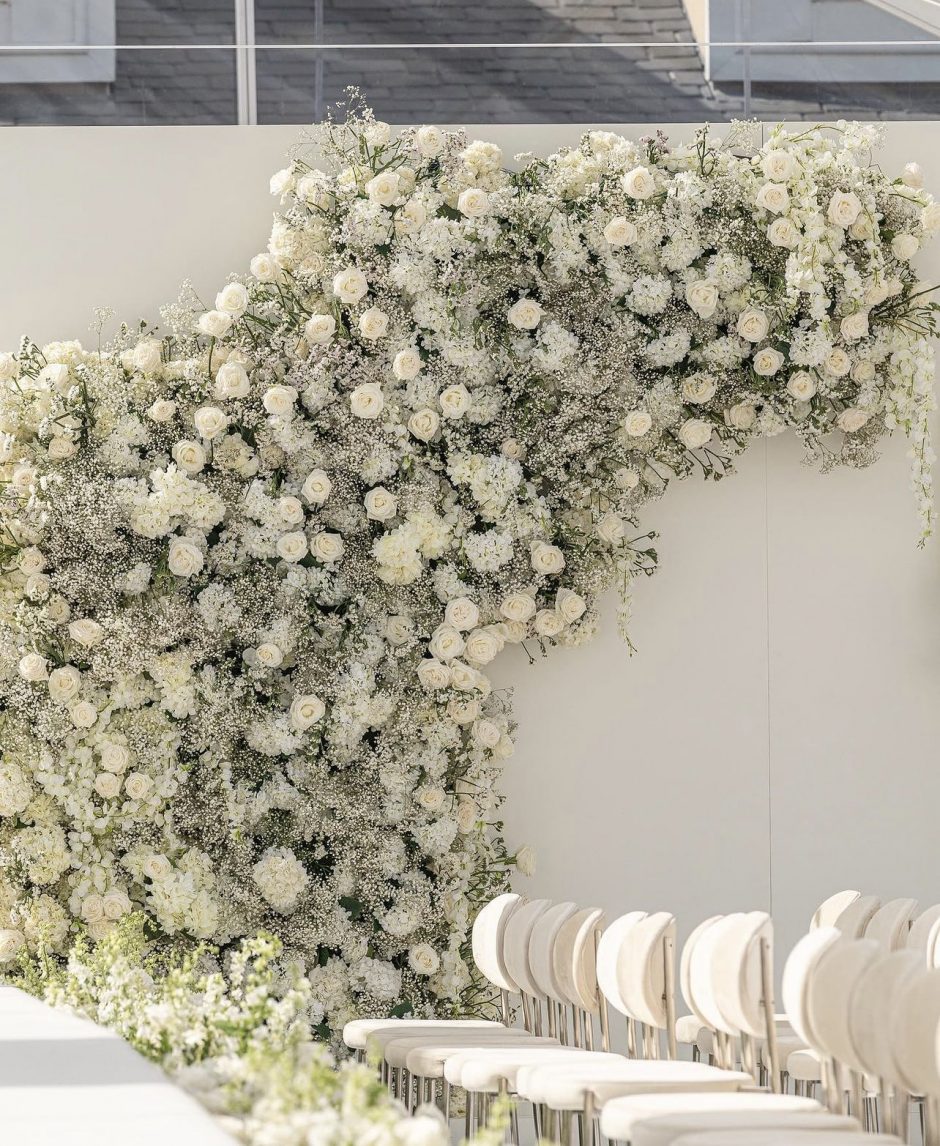 Backdrop of white flowers for a white monochrome wedding theme.