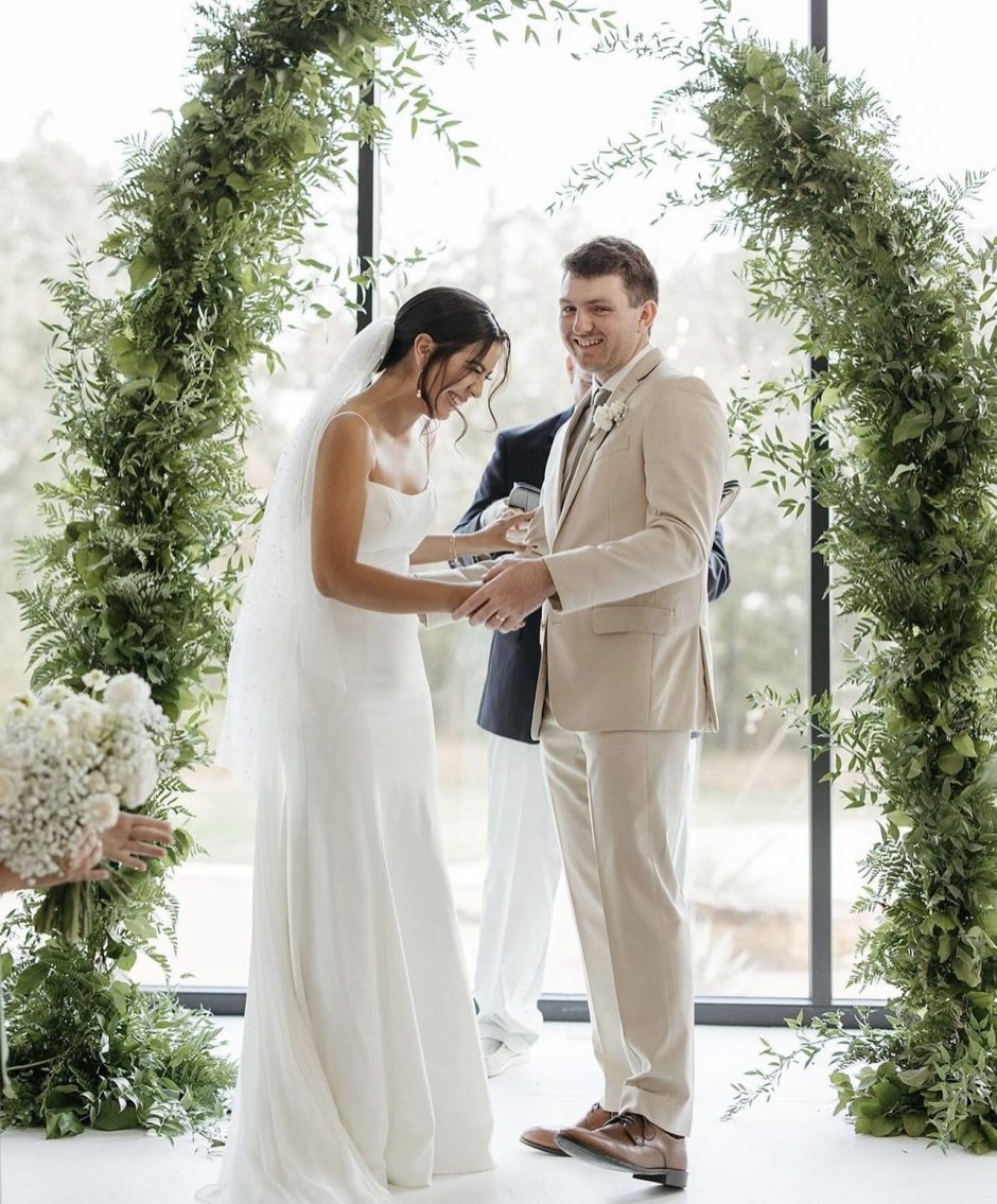 Newlywed couple with background of greenery and neutral colors.