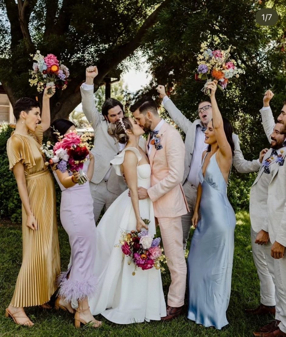 Newlywed couple with bridal party in colorful colors.