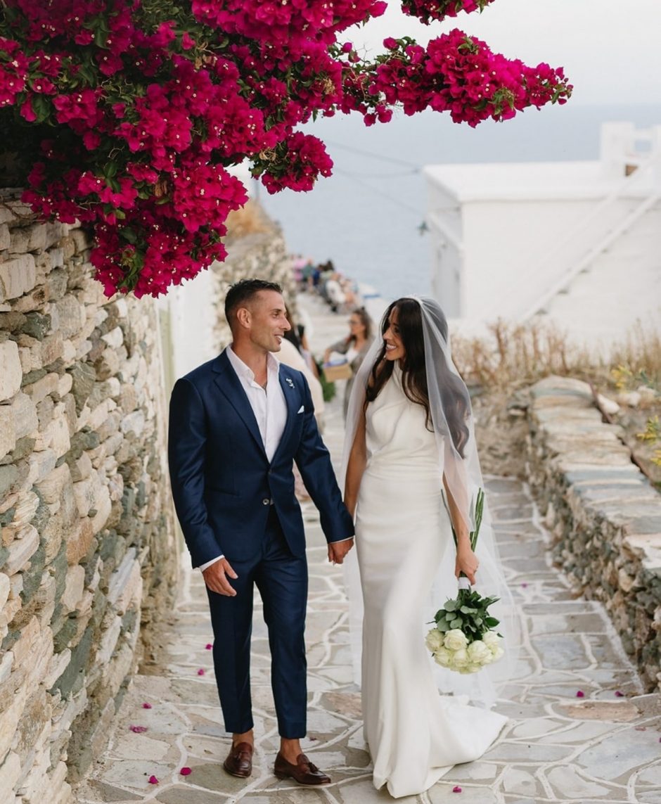 Couple strolling down a Greek island after getting married.