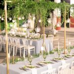 Greek wedding reception with tables full of greenery.