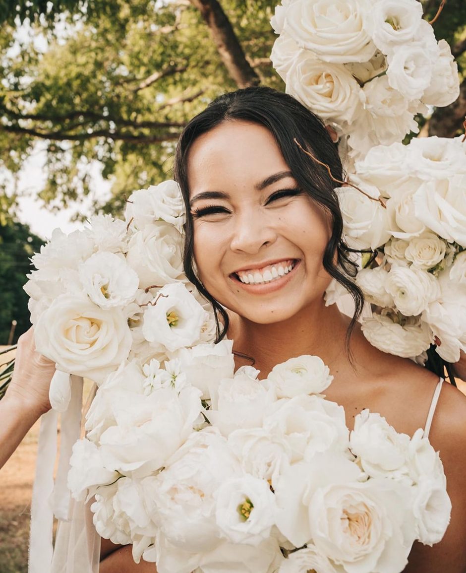 Bride surrounded by white flowers.