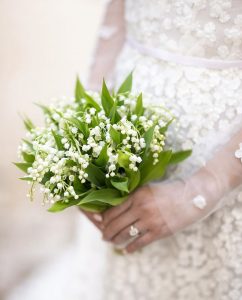 Bride holding bouquet of lily of the valley.