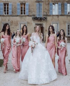 Bride and bridesmaids holding bouquets of pink wedding flowers.