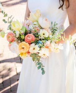 Bride holding bouquet of ranunculus.