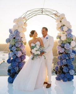 Newlywed couple with background of blue hydrangeas.