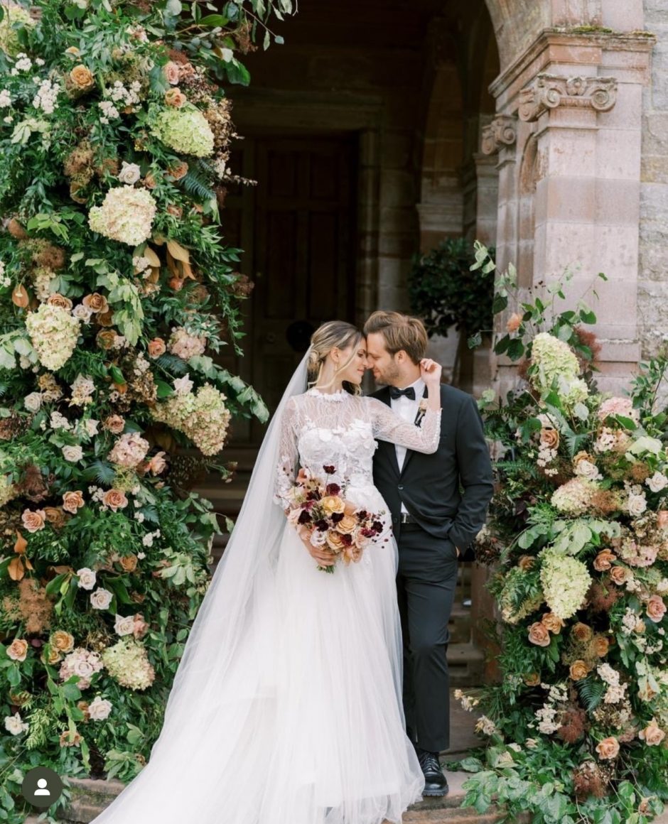 Newlywed couple at Leslie Castle with brown and burgundy flowers.