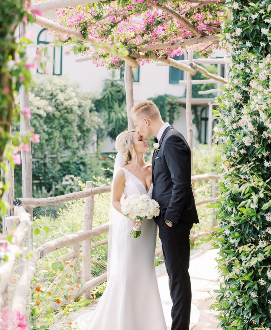 Newlywed couple with backdrop of floral paradise theme.