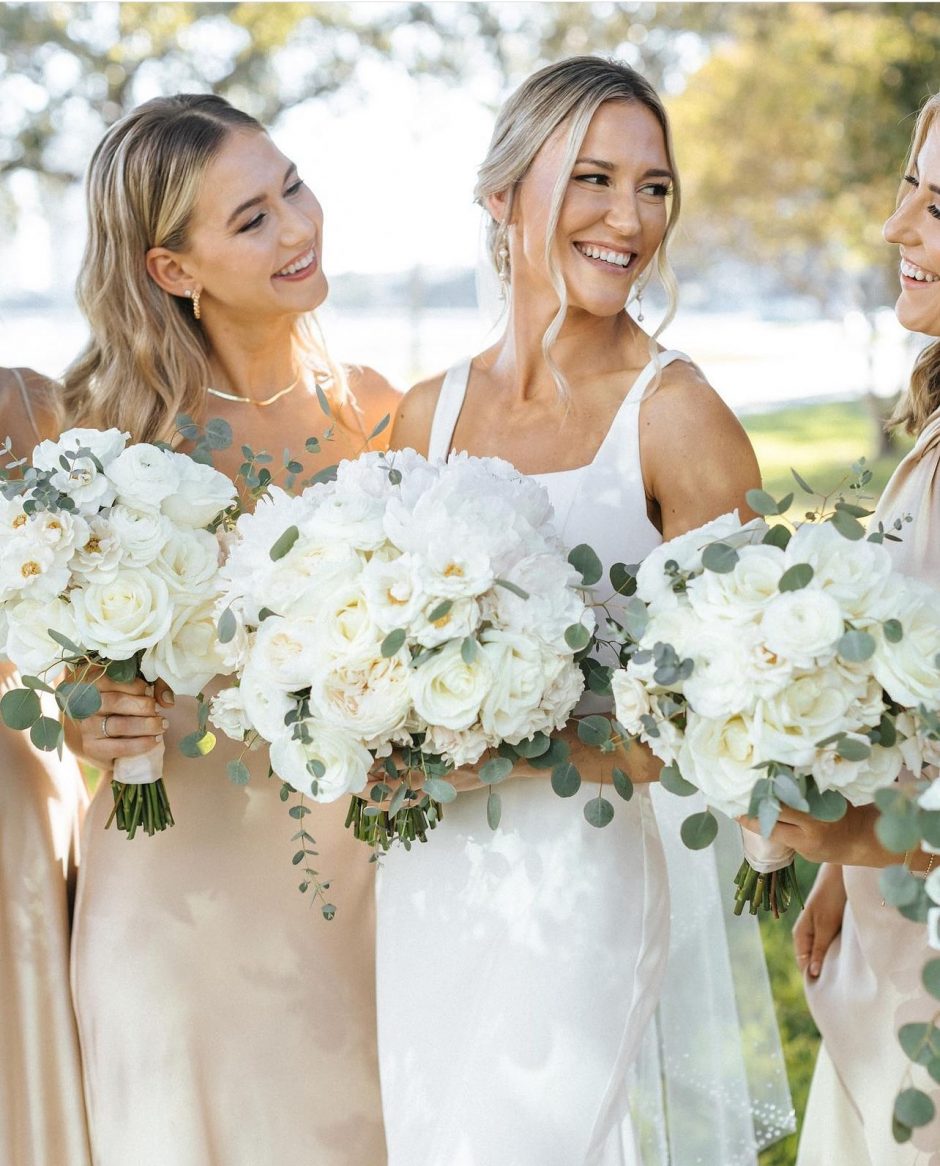 Bridal party with bouquets of white roses and silver dollar eucalyptus.