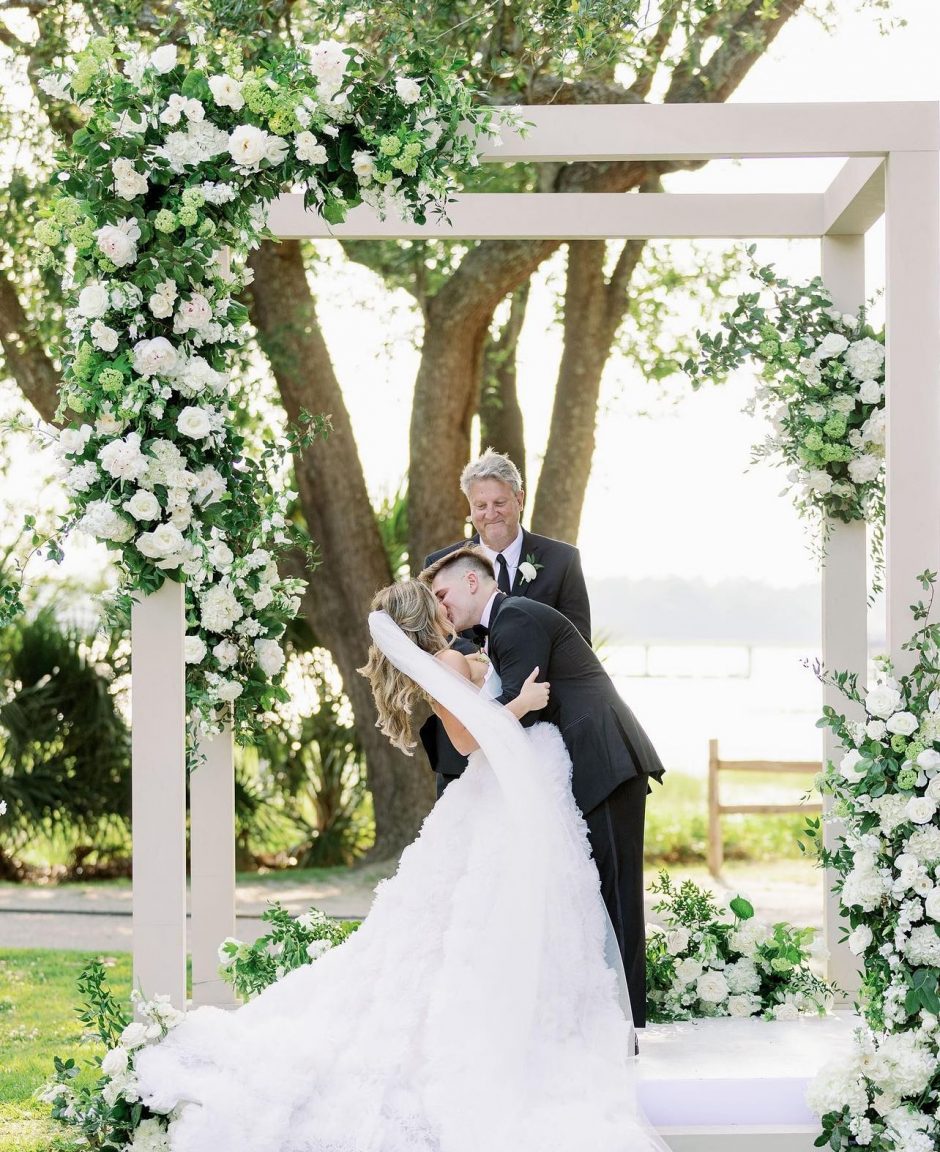 Couple just go married with background of white flowers.