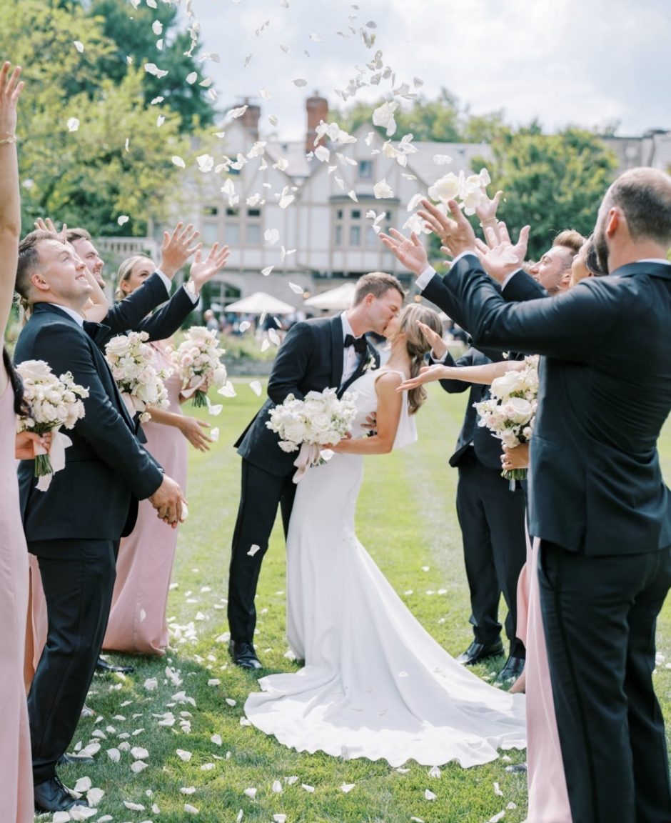 Newlywed couple together with ivory and blush roses.