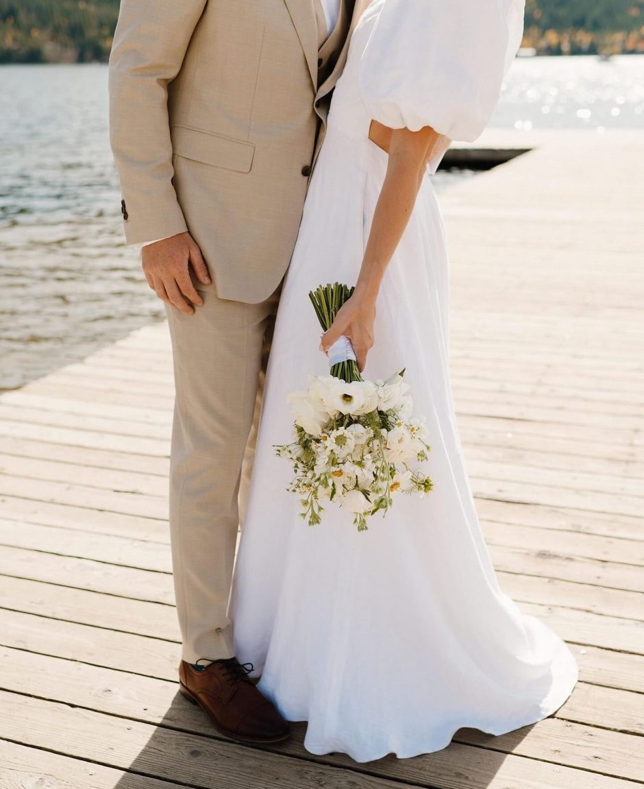 Bride holding bouquet of white wedding flowers.