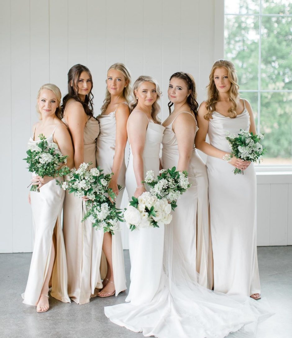 Bridal party all holding bouquets with white flowers.
