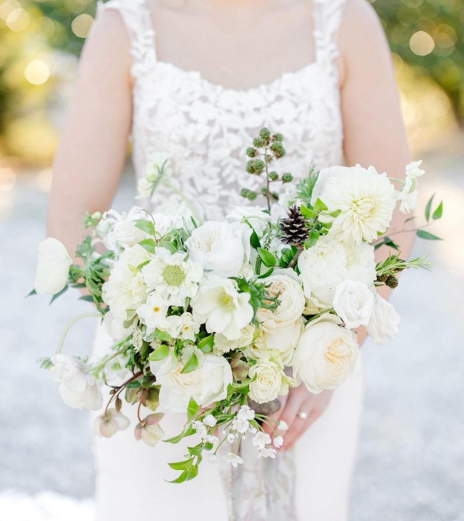 Wedding bouquet with white blooms and pinecones.