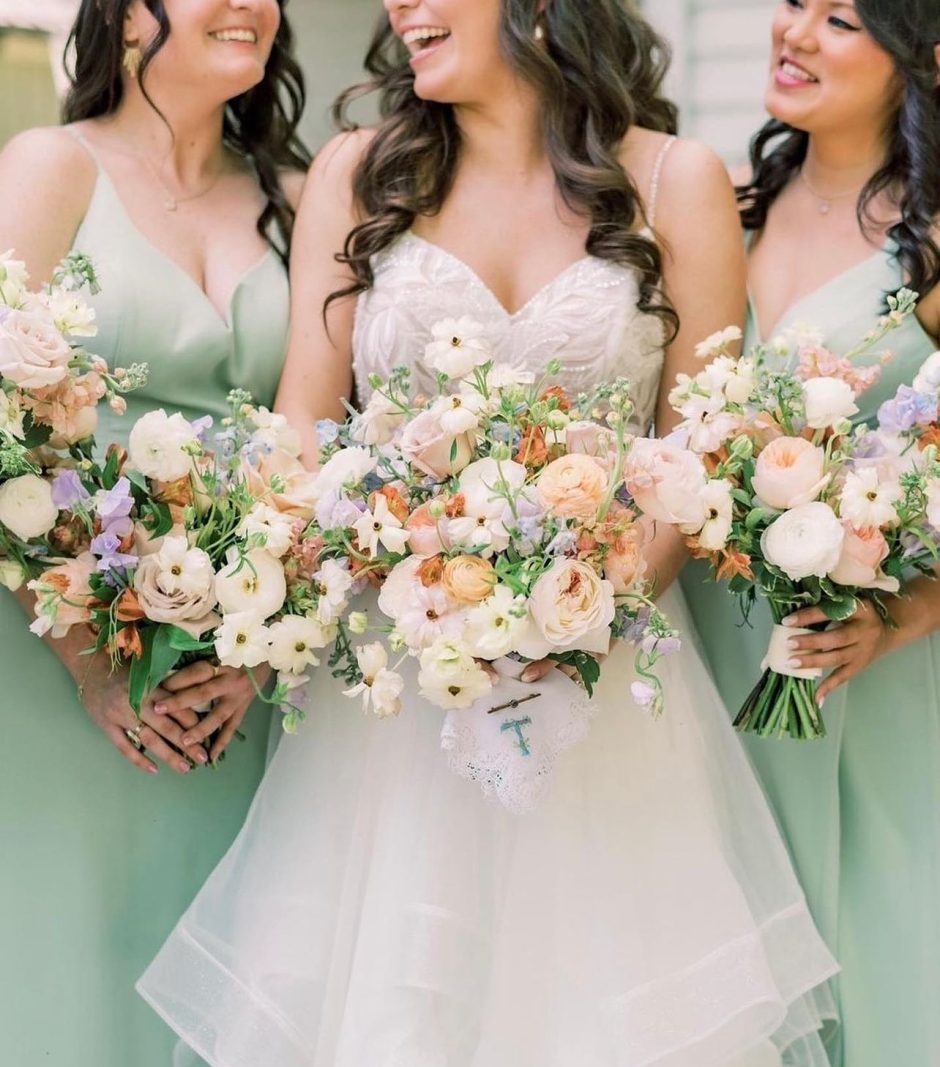 Bridal party with ranunculus and roses for wedding flowers.