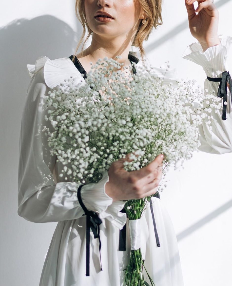 Woman holding a baby's breath bouquet.