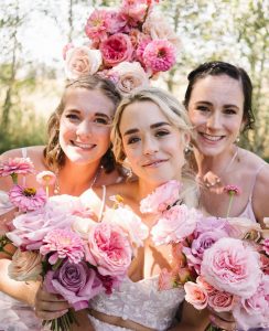Bride and bridesmaids with pink flowers.