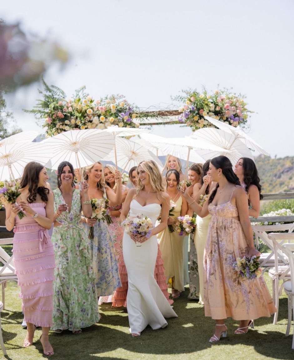 Bride and bridesmaids with pastel color wedding flowers in garden themed party.