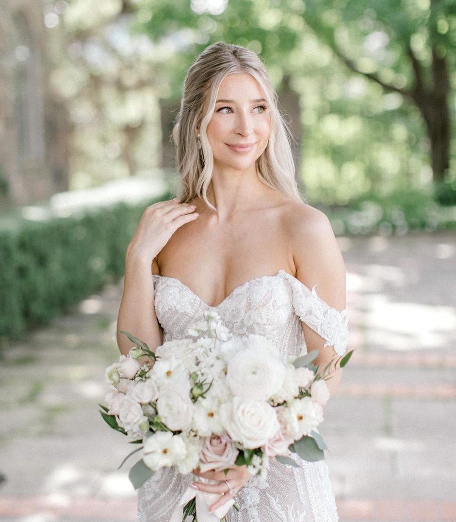 Bride with wedding bouquet with blush and cream florals.