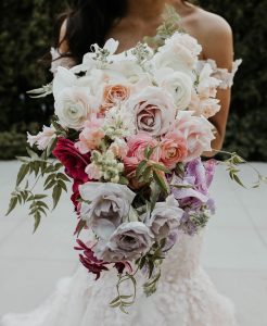 Woman holding gorgeous wedding bouquet with fresh flowers.