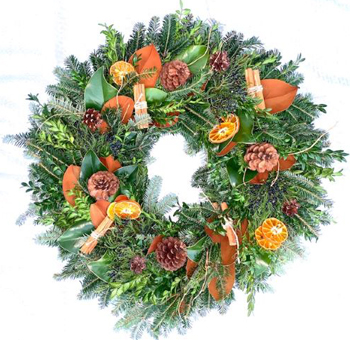 Orange Spice Wreath with magnolia leaves, cedar, orange slices, pinecones, and cinnamon sticks. A fragrant and festive accent for indoor or covered outdoor spaces.